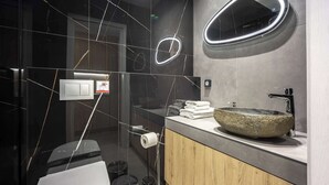 A modern bathroom with a stone sink, a mirror, and a towel rack. - Chic Studio | Syntagma | Worn Bldg Entrance (Athens)