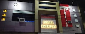 Un edificio con un llamativo letrero que dice 'HOTEL AMERICAN'.