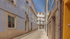 A narrow street with buildings on either side, featuring tiled facades and a clear sky. - Downtown Elegant Studio by Vacationy (Porto)