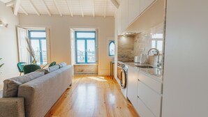 Een moderne keuken met houten vloeren, een ingebouwde wasmachine en een groot raam.