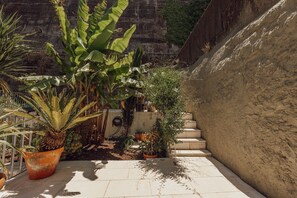 A paved outdoor area with potted plants, a concrete wall, and a staircase. - Bridge Pool Retreat by Vacationy (Vila Nova de Gaia)