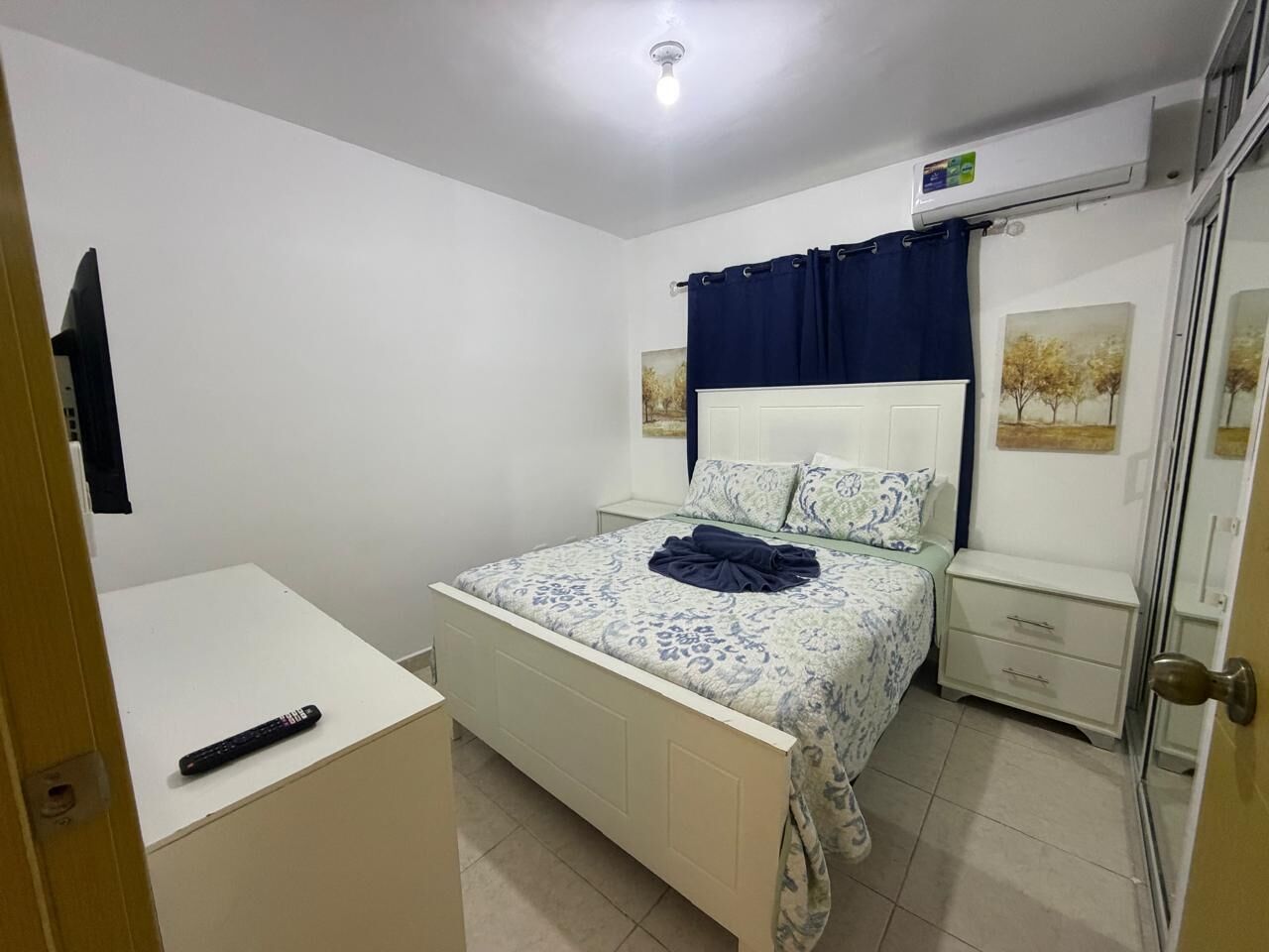 A bedroom with a bed, bedside tables, a wardrobe, and a door.