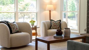 A living room with two beige armchairs, a wooden coffee table, a lamp, and a vase. - Lakeside retreat minutes walk from Douglas Beach! (Douglas)