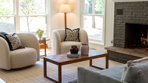 A cozy living room with a fireplace, a sofa, a coffee table, and a lamp. - Lakeside retreat minutes walk from Douglas Beach! (Douglas)
