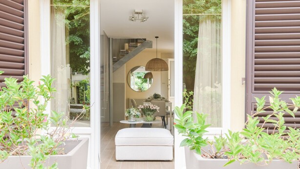 A modern interior with a staircase, a dining area with a round mirror, and potted plants. - Refined And Elegant Two-Bedrooms Apartment Near Rocca Del Cerruglio In Montecarlo (Montecarlo)