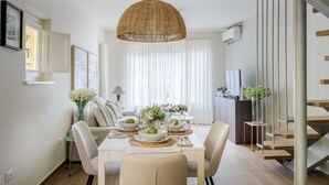 A dining area with a table set for four, a hanging light fixture, and a staircase. - Refined And Elegant Two-Bedrooms Apartment Near Rocca Del Cerruglio In Montecarlo (Montecarlo)