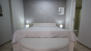 Une chambre à coucher avec un lit, des lampes de chevet, une table de chevet et une chaise.