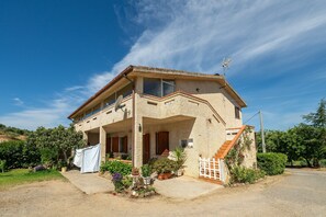 A two-story house with a balcony, a satellite dish, and a staircase leading to the upper floor. - Casa Vacanza Iris surrounded by Sulcis nature (Perdaxius)