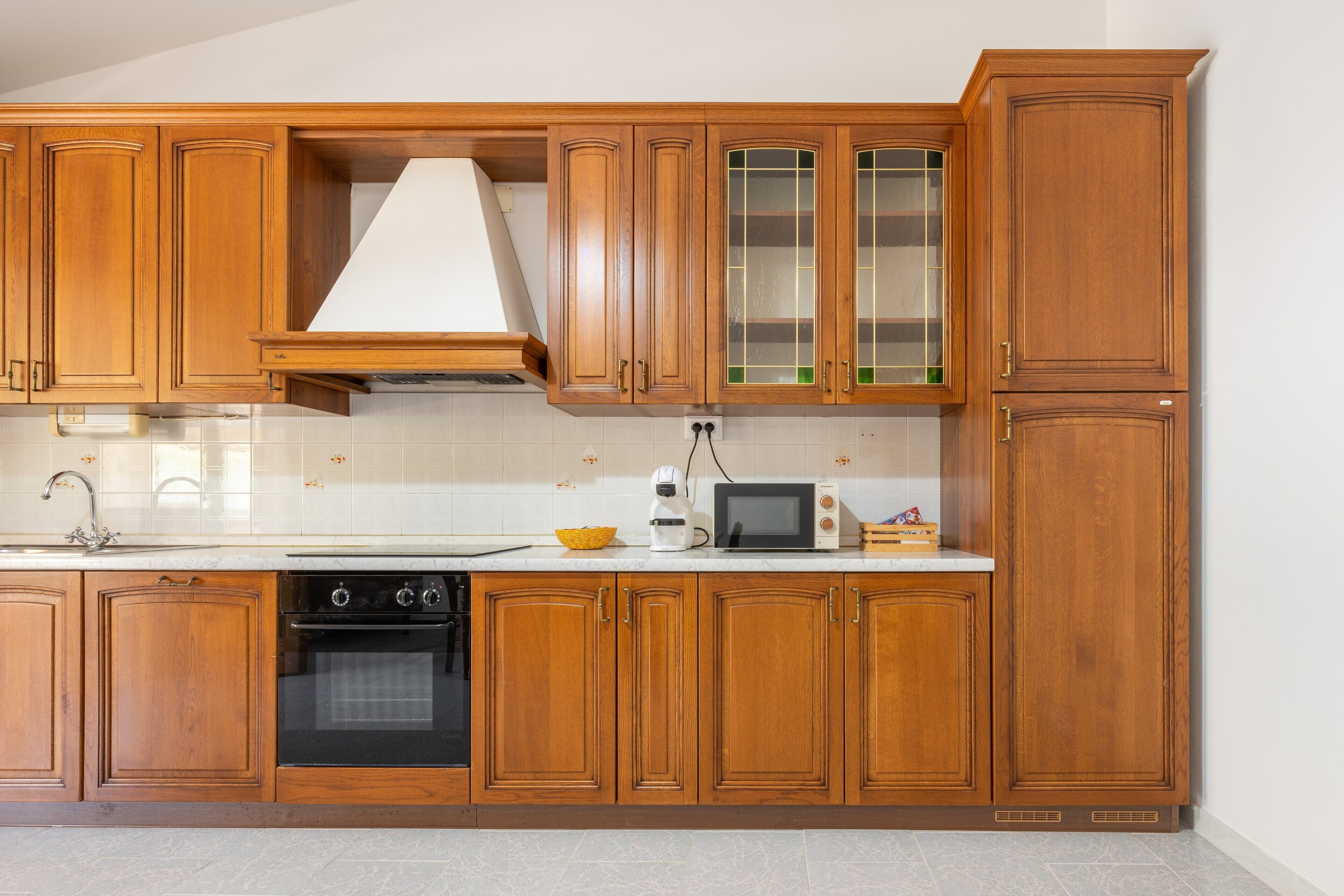 Une cuisine avec des meubles en bois, un four à micro-ondes, une cuisinière et un évier.