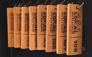 Varias etiquetas de madera con la leyenda 'HOTELS DAUN' grabada, sobre un fondo negro.