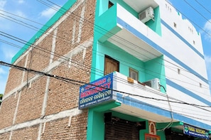 Un edificio de dos pisos con un letrero que dice 'Panda Medicines' y un letrero que dice 'Hotel Abban Residency'.