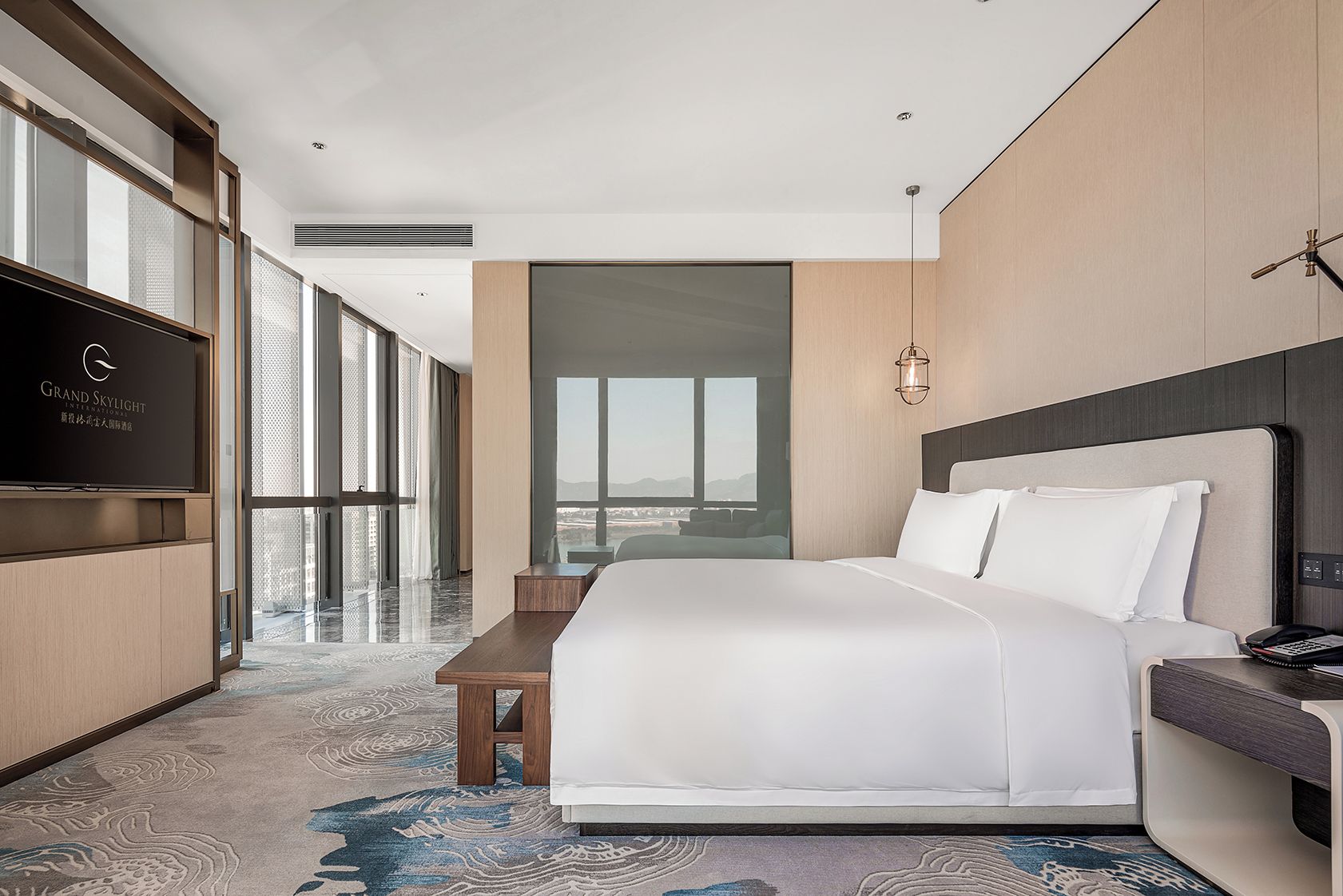Habitación de hotel con una cama grande, un escritorio, un televisor y vistas de la ciudad.