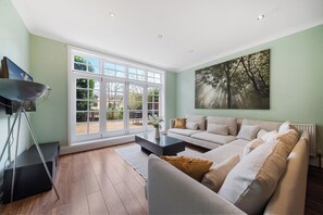 A living room with a sofa, coffee table, and a tripod. - Hidden Gem 15 mins to London Bridge slps 6 (London)