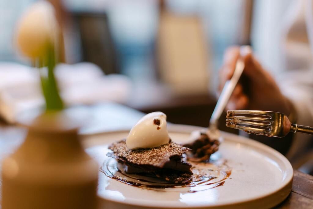 A dessert with a scoop of ice cream on top, a chocolate base, and a dusting of powdered sugar.
