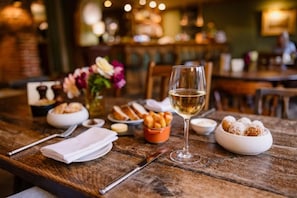 A wooden table with a wine glass, bread, and dessert. - The Bildeston Crown (Bildeston)