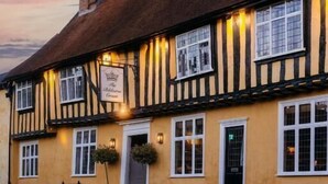 A traditional building with a thatched roof, multiple windows, and a sign indicating it is a pub. - The Bildeston Crown (Bildeston)