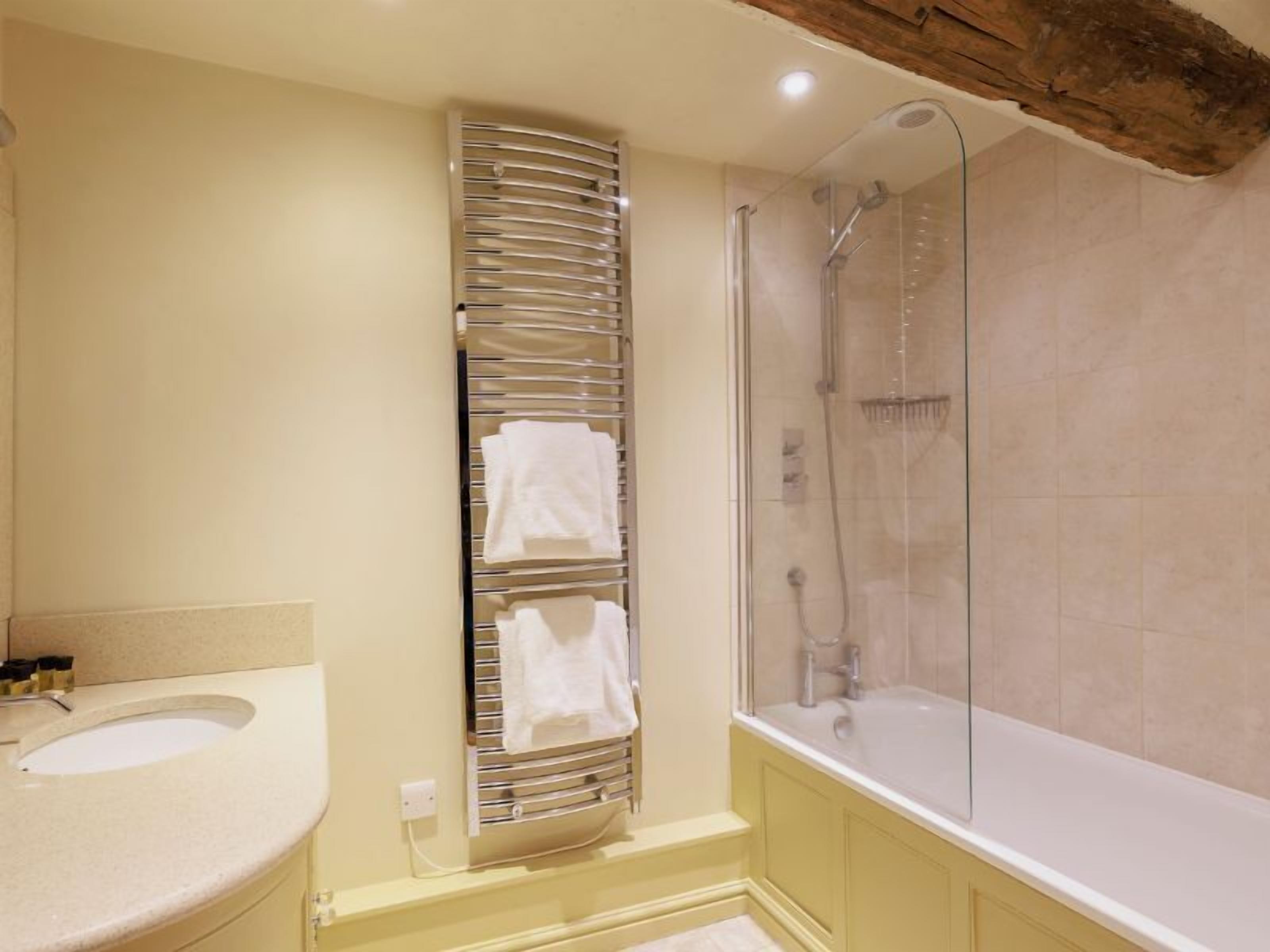 Un baño con lavamanos, cabina de ducha de vidrio y bañera.