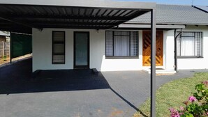 Et moderne hus med to etager, en overdækket veranda, en hoveddør og en garage.