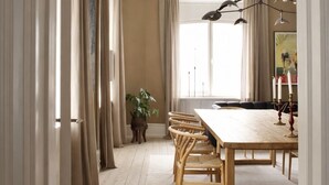 Een eethoek met een houten tafel, stoelen en een hanglamp.