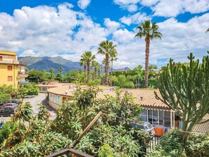 A residential area with houses, palm trees, and a mountain in the background. - Loving Gift - Giardini Naxos (Giardini Naxos)