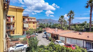 A residential area with buildings, parked cars, and palm trees. - Loving Gift - Giardini Naxos (Giardini Naxos)