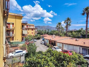 A residential area with buildings, parked cars, and palm trees. - Loving Gift - Giardini Naxos (Giardini Naxos)