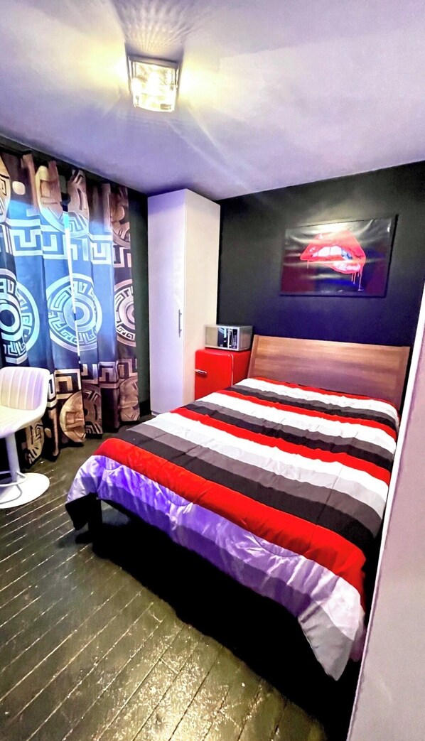 A bedroom with a bed, a chair, a red cabinet, and a wall with a painting. - Luxury KIA Room D
Private master 
In Richmond hill (Richmond Hill)