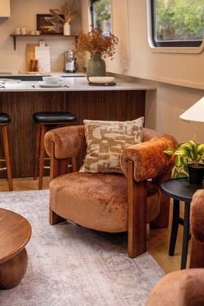 A cozy seating area with a cushioned chair, a small round table, and a bar area with stools.