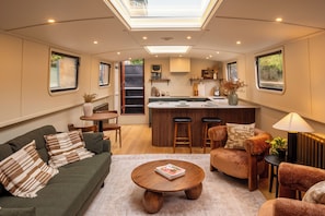 A compact living space with a kitchenette, a sofa, a coffee table, and a dining area.