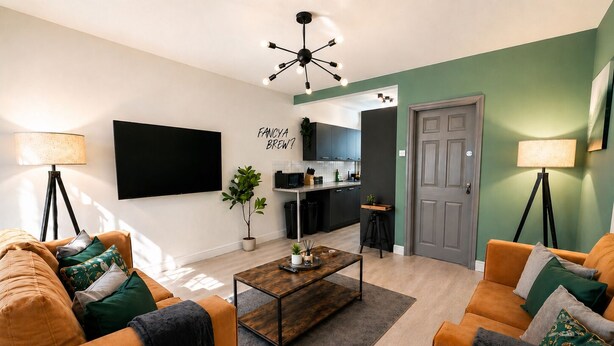 A modern living room with a sofa, coffee table, and a flat-screen TV. - 6-bed House - Sleeps 11 - Garden - Parking (Sheffield)
