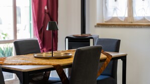 Ein Essbereich mit Tisch, Stühlen, einer Lampe und einem Fenster mit Vorhängen.