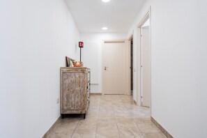 Ein Flur mit einem Holzkasten, einer Tür und einem Lichtschalter an der Wand.