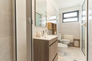 Ein modernes Badezimmer mit Dusche, Toilette und Waschbecken.