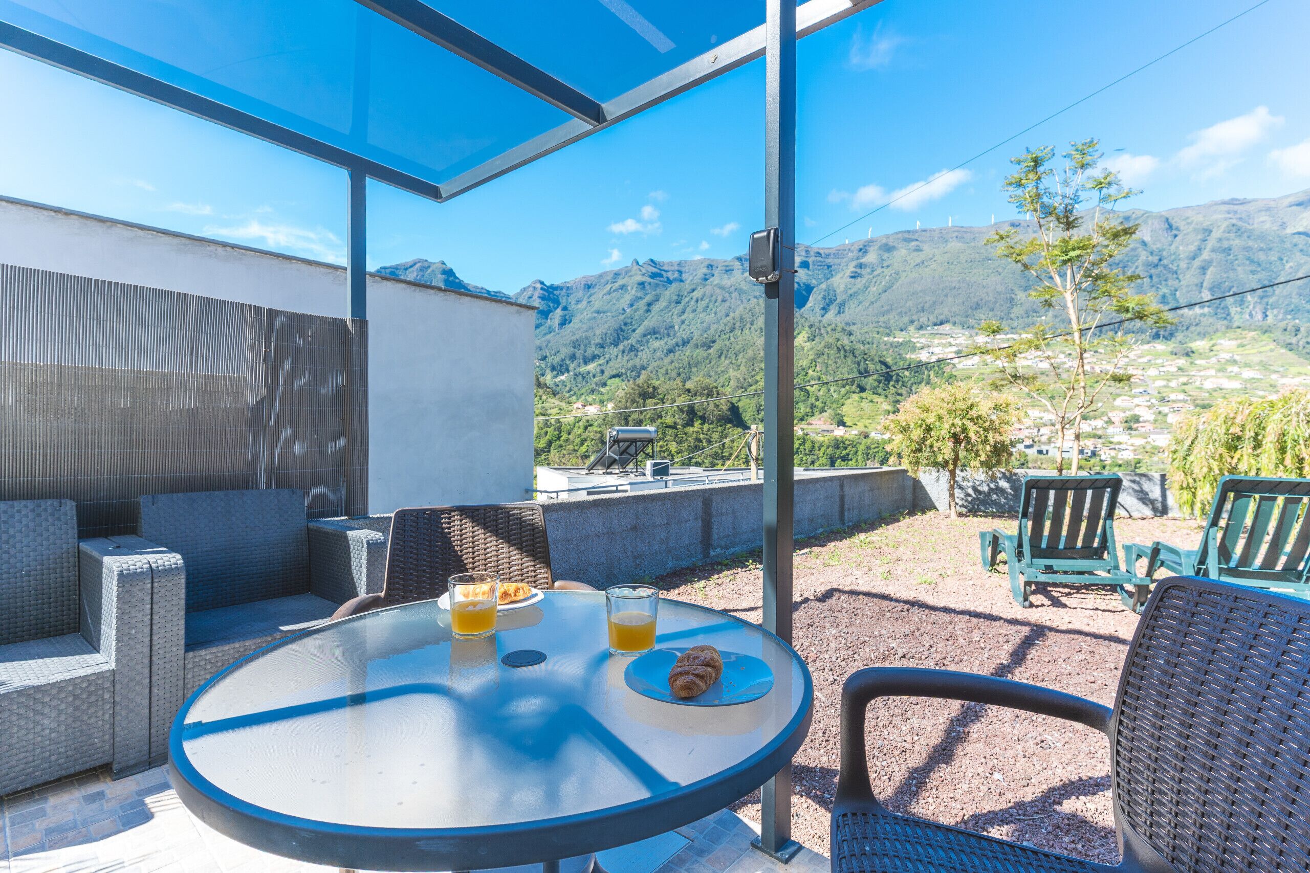 Un espace extérieur aménagé avec une table, des chaises et une vue sur les montagnes.