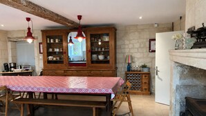 Une cuisine rustique avec une table en bois, un meuble encastré et un mur en pierre.