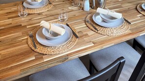 A dining area with a wooden table set for four, a sofa in the background, and a window with a view. - Holiday Living Zennern - near Fritzlar & Edersee (Wabern)