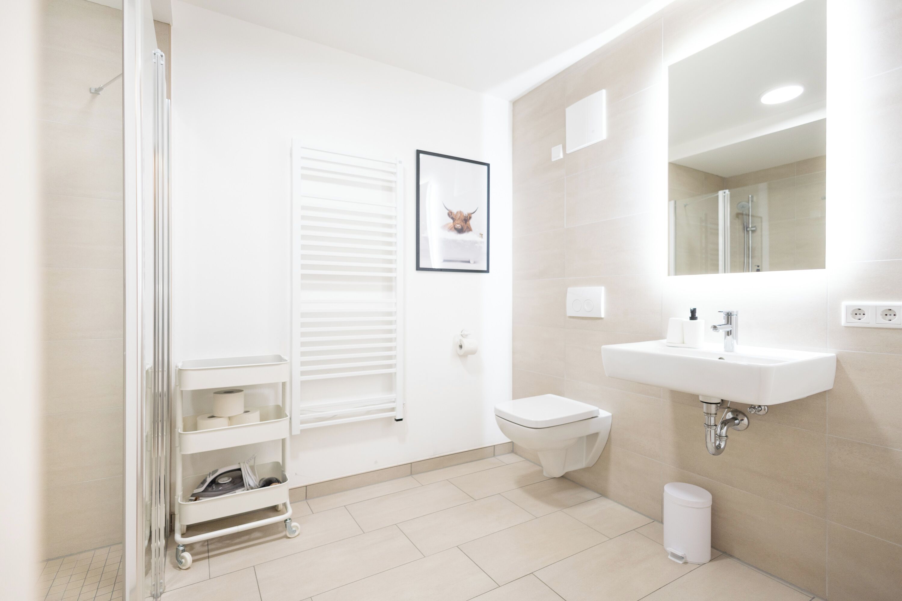 Ein modernes Badezimmer mit Toilette, Waschbecken und Dusche.