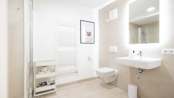 Ein modernes Badezimmer mit Toilette, Waschbecken und Dusche.
