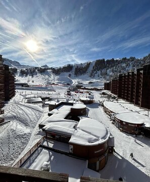 A ski resort with snow-covered buildings, a ski lift, and a mountain backdrop. - Mountain apartment 5people ski in ski out la plagne bellecôte (La Plagne Tarentaise)