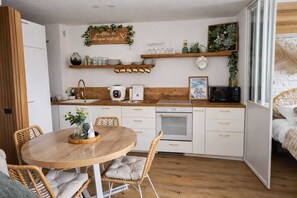 A compact kitchen with a dining area, a microwave, a rice cooker, and a small oven. - Mountain apartment 5people ski in ski out la plagne bellecôte (La Plagne Tarentaise)