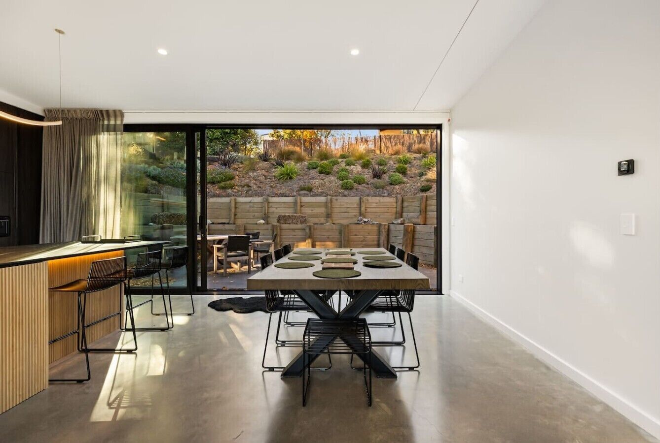 Gather around your sleek dining table for memorable meals while soaking in views of the drought-resistant garden through floor-to-ceiling glass