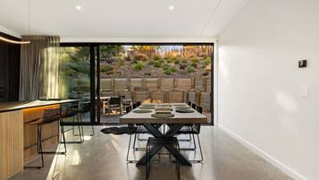Gather around your sleek dining table for memorable meals while soaking in views of the drought-resistant garden through floor-to-ceiling glass