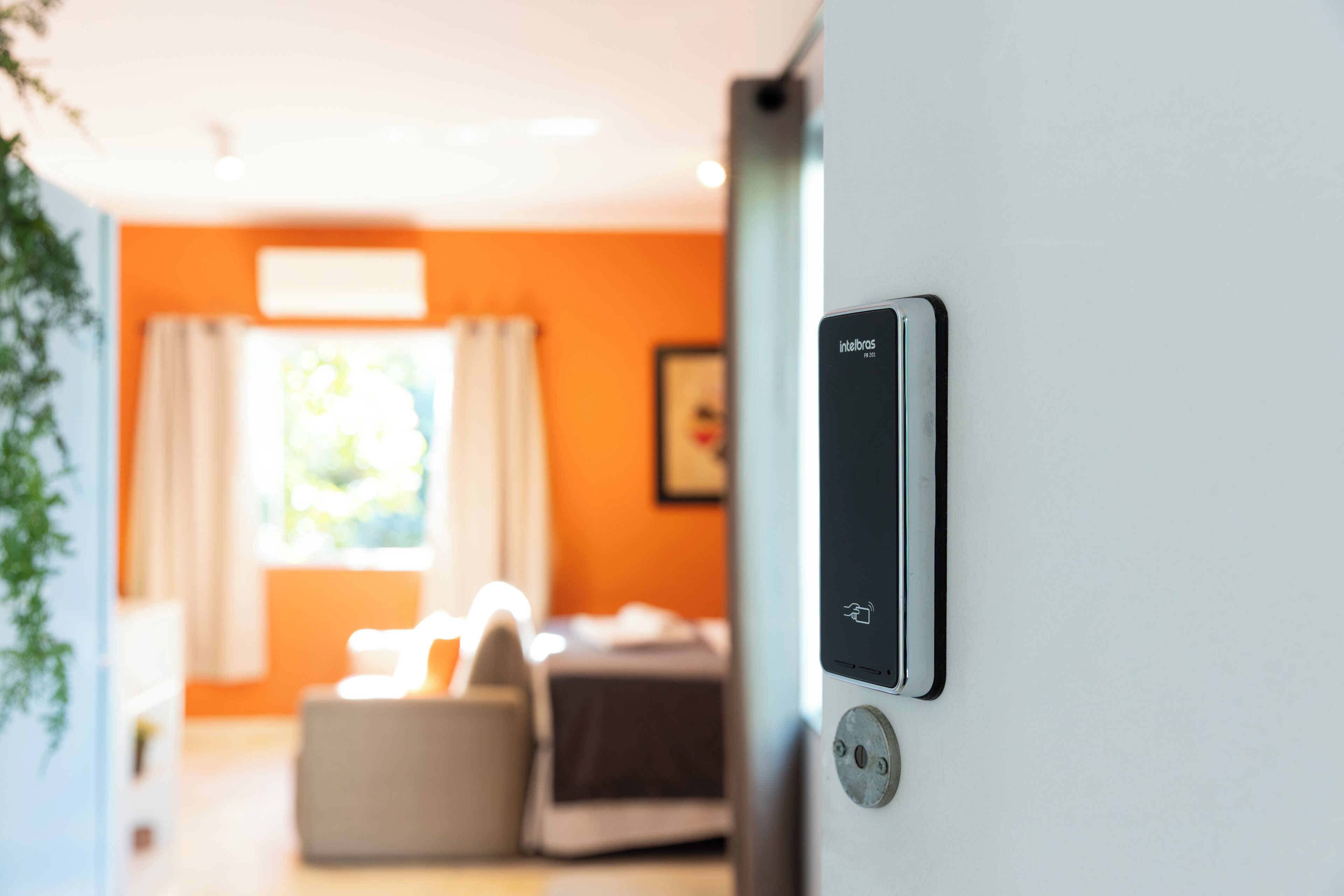 A modern room with a bed, a bedside table, and a wall-mounted control panel.