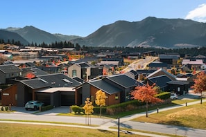 Ein Wohngebiet mit modernen Häusern, einer Straße und Bergen im Hintergrund.