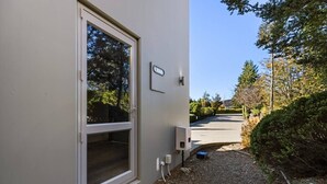 A building with a large window, a door, and a wall-mounted device. - Lake & Alps on Your Doorstep | Resort Facilities (Wānaka)