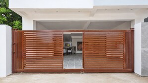 A modern building entrance with a wooden gate, a tiled floor, and a visible interior with a dining area. - Hotel Rahi Residency (Varanasi)