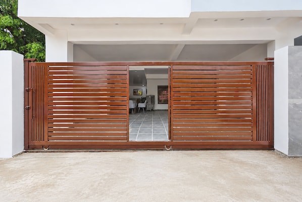 A modern building entrance with a wooden gate, a tiled floor, and a visible interior with a dining area. - Hotel Rahi Residency (Varanasi)