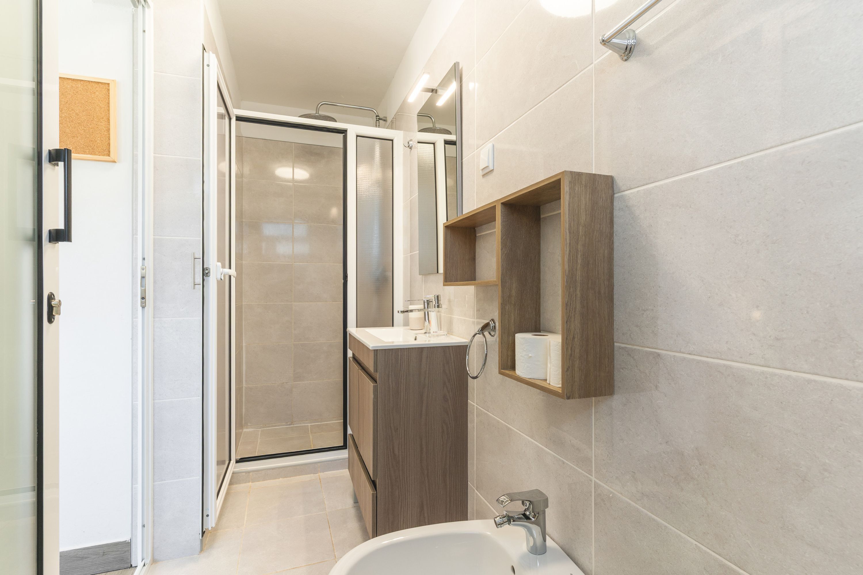 A modern bathroom with a shower, sink, and vanity.