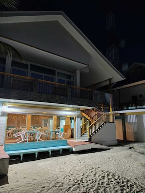 Una propiedad frente a la playa con un espacio exterior cubierto, una escalera y una piscina.