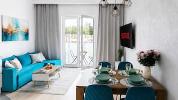 Leilighet – superior, balkong, bakgårdsutsikt | Oppholdsområde | En 150-centimeters Flatskjerm-TV med Parabol-TV